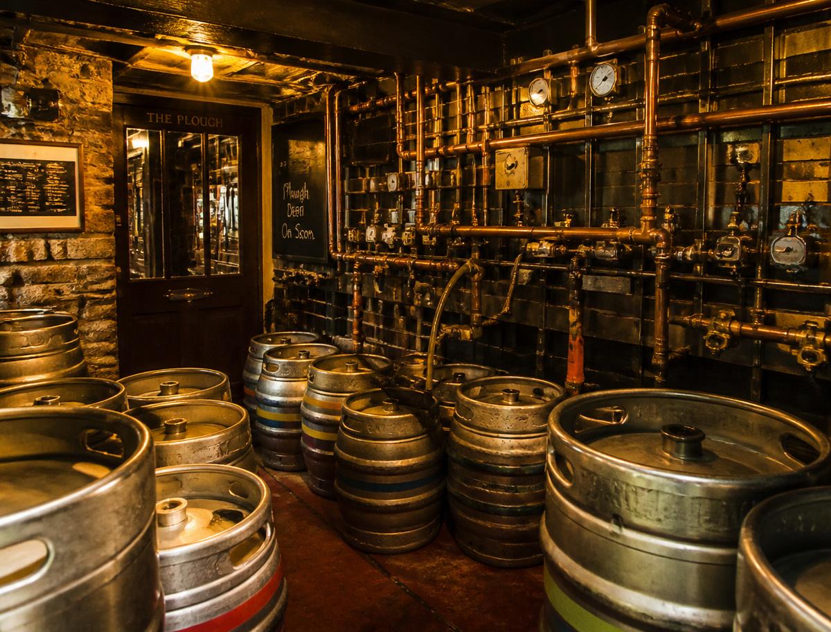 Warm pub cellar with copper pipes and beer kegs